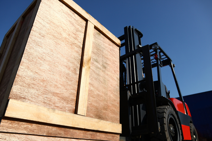 A forklift loading a container into Guardian Relocation Storage Facility